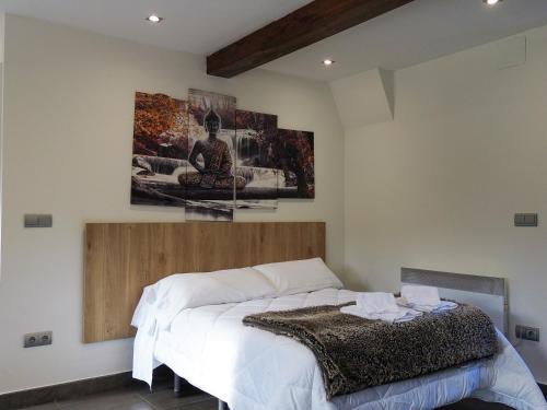 une chambre avec un lit et un tableau au mur dans l'établissement Casa Obregón Cabárceno 3000, à Lusa