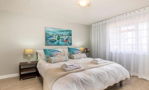 a bedroom with a large bed with towels on it at A Whale of a Time Knysna in Knysna