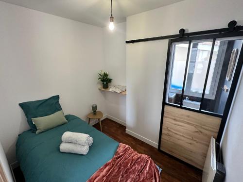 昂古莱姆Un refuge charmant derrière la gare的一间小卧室,配有绿色的床和窗户