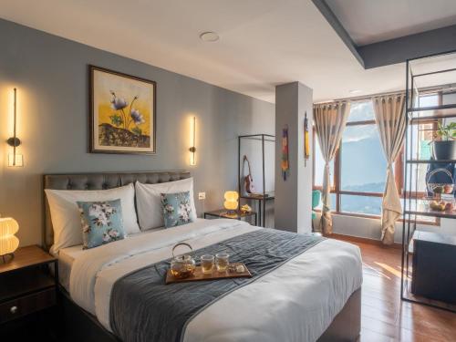 ガントクにあるMoustache Hostel Gangtokのベッドルーム1室(大型ベッド1台、トレイ付)