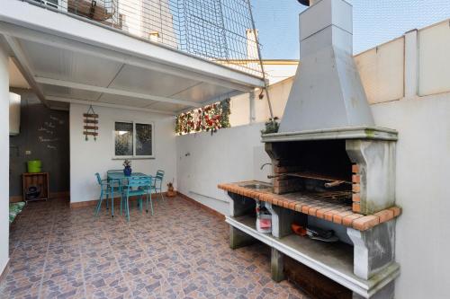 an outdoor patio with an outdoor pizza oven at Tour House in Rio Tinto