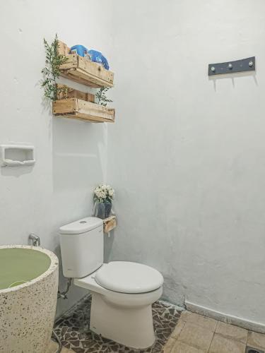 a bathroom with a toilet and a bath tub at Little Loti Sikumana in Maulafa
