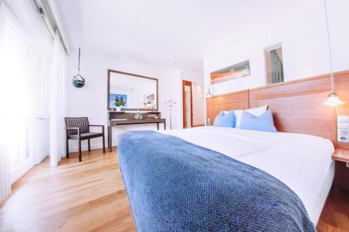 Un dormitorio con una cama, un escritorio y un espejo. en Hotel Zum Ochsen, en Oberstenfeld