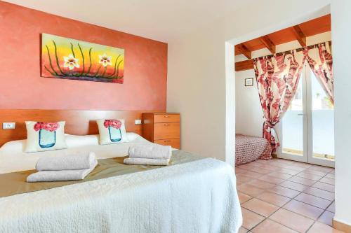 una camera da letto con due letti e una finestra di Villa Juan by Villa Plus a Portopetro