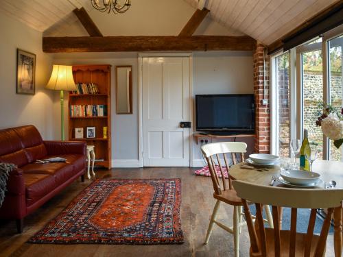 een woonkamer met een bank en een tafel bij The Dairy - Uk50885 in North Walsham