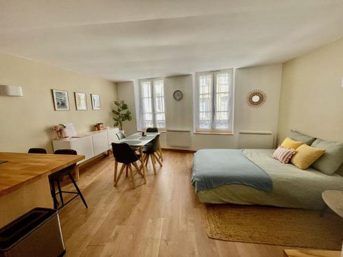 ein Schlafzimmer mit Bett und Tisch und eine Küche in der Unterkunft Les Gîtes de l'ile à Metz in Metz