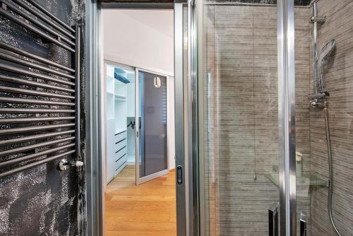 ジェノヴァにあるComfort-Moderno and Parkingの家のウォークインシャワーに通じるガラスのドア