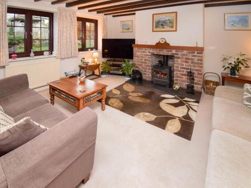 a living room with a couch and a fireplace at 1 Stag Inn Cottages in Milburn