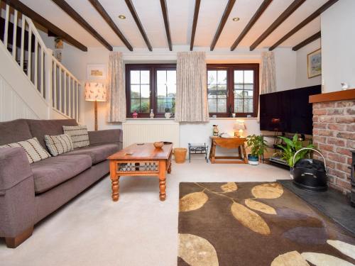 a living room with a couch and a table at 1 Stag Inn Cottages in Milburn