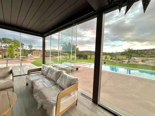 ein Wohnzimmer mit einem Sofa und Poolblick in der Unterkunft Natura-Resort Les Pletes in Palouet