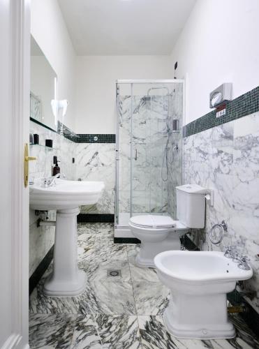 a bathroom with two sinks and a toilet and a shower at Hotel Leon D´Oro in Prague