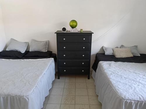 a bedroom with two beds and a dresser at 4 Palmas in Guadalajara