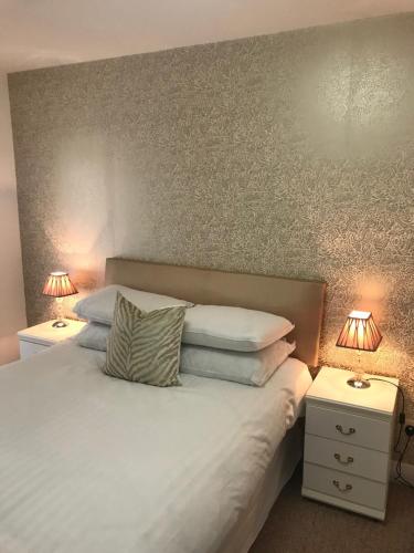 a bedroom with a white bed with two night stands at The Downtown Loft in Buncrana