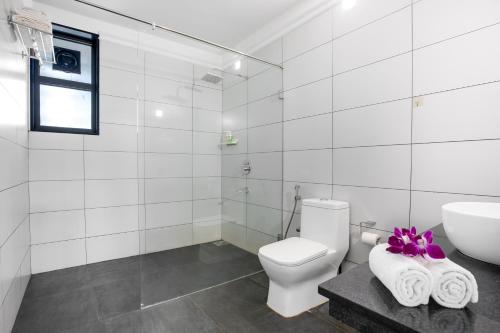 a white bathroom with a toilet and a sink at Crystal Village in Nagoa-Bardez