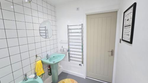 a bathroom with a green sink and a toilet at Stepping Stones in Perranporth