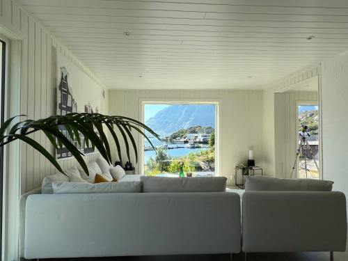 a living room with a couch and a large window at Aurora Bay Villa Lofoten 罗弗敦极光湾海景顶层别墅 in Sund