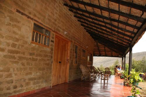 a person sitting on a porch of a house at Monzaque- paraíso de bachué in El Barrial