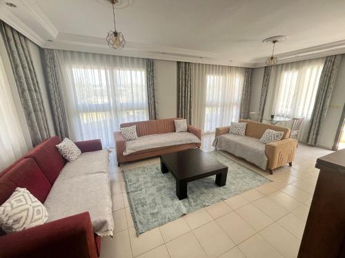 a living room with two couches and a table at ALTINKUMDA 12 Kişilik ÖZEL HAVUZLU VİLLA in Didim