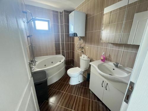 a bathroom with a sink and a toilet and a tub at ALTINKUMDA 12 Kişilik ÖZEL HAVUZLU VİLLA in Didim