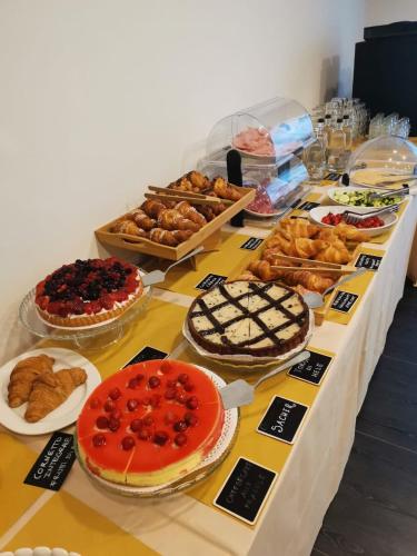 a table with different types of desserts and pastries at Maestrale Resort Hotel - Grosseto in Grosseto