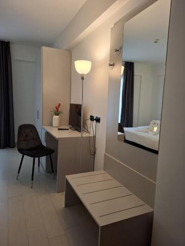 a room with a bed and a desk and a mirror at Maestrale Resort Hotel - Grosseto in Grosseto