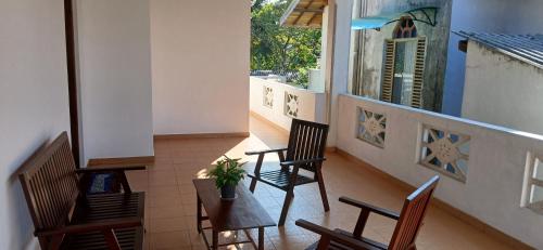 安伯朗戈德Ambalangoda Villa 3的门廊配有椅子和桌子,设有窗户