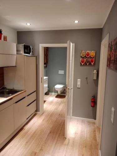 a kitchen with white cabinets and a door to a bathroom at Stadtnah an der Förde 5705 in Flensburg