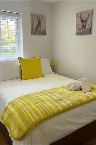 a bed with two towels on it in a bedroom at Beautiful renovated cottage in Mersham Ashford Kent in Mersham
