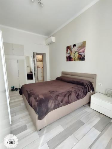 a bedroom with a large bed in a white room at Paty's House Milano in Milan