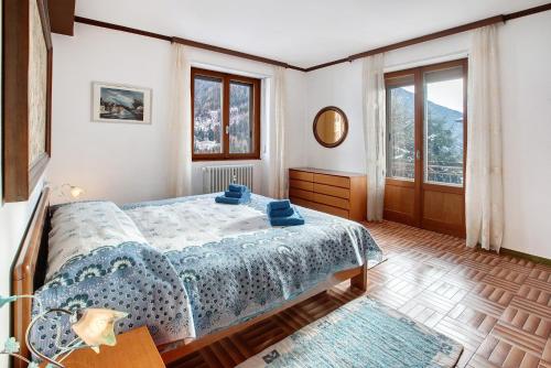 松达洛Appartamento Alice的一间卧室，里面有一张床和一扇大窗户。