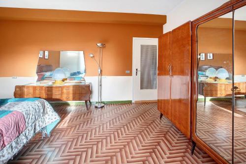 松达洛Appartamento Alice的带床和大镜子的卧室