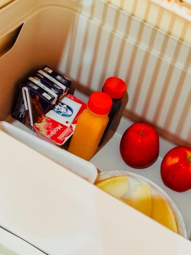 een open koelkast met appels en flessen sap bij Pousada Nosso Bosque in Porto Belo