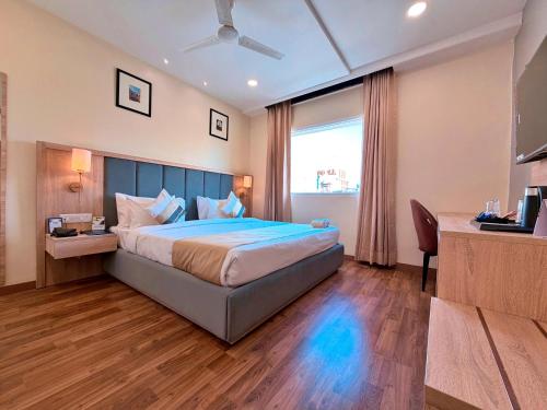 Una cama o camas en una habitación de asar Capoors Hotel