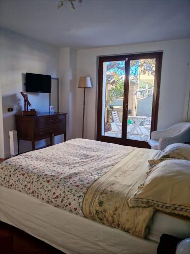 a bedroom with a large bed and a window at Daphne Experience - Home, Harmony and Garden in Loreto Aprutino