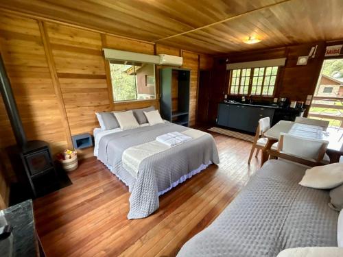 a bedroom with two beds and a fireplace and wooden floors at Namastê - Hospedaria de Altitude in Urubici