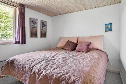 una camera da letto con un letto con piumone rosa e una finestra di 30493-Odder-Snekkeager-21 a Odder