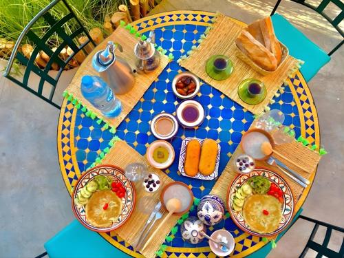 uma mesa com pratos de comida em cima em Guest house DARNART Hostel em Aourir