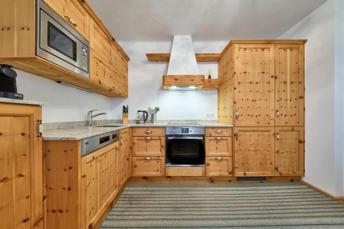 a kitchen with wooden cabinets and a sink and a microwave at Haus Erni in Bad Aussee