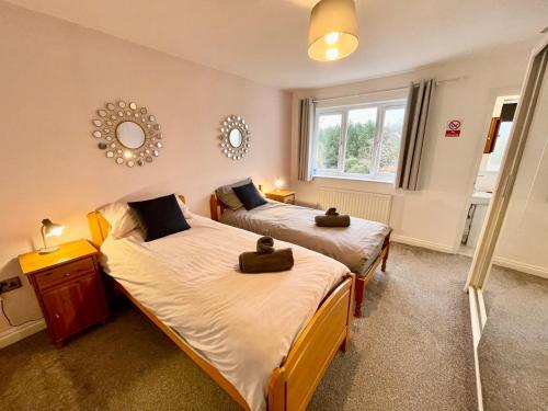 um quarto com duas camas e uma janela em Large 5 bed detached house near Stansted Airport with Parking for 2 vehicles! Stansted Stays em Stansted Mountfitchet