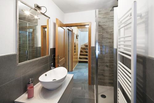 a bathroom with a white sink and a mirror at Appartamento Primavera 3 in Moena