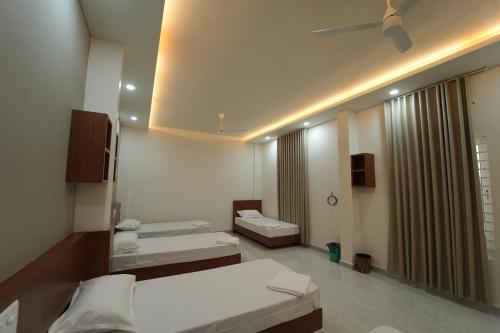 SK Premium Residency في Etakkare: غرفة فندقية بسريرين ومرآة