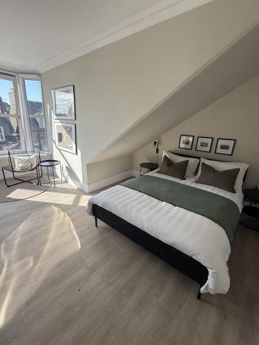 a bedroom with a large bed and a large window at Park House Rooms in Aberdeen