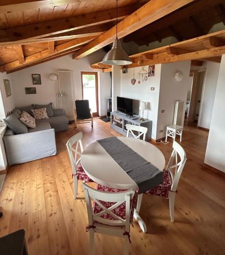 a dining room and living room with a table and chairs at Albaredo Wood Terasse in Rotzo