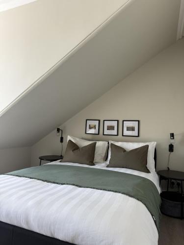 a white bedroom with a large bed with pillows at Park House Rooms in Aberdeen