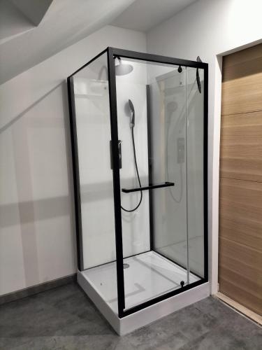 a glass shower in a room next to a door at Le petit cauchois in Fécamp