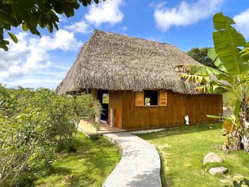 una casa con techo de paja y un camino en Finca Zayan, en El Copé