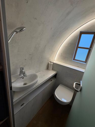 a bathroom with a sink and a toilet and a window at Avalon Ferienpark Bad Bevensen in Bad Bevensen
