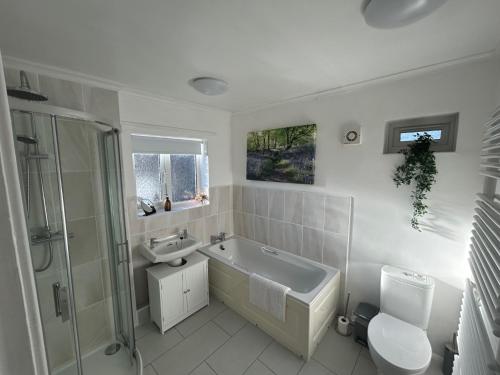 a bathroom with a sink and a tub and a toilet at Glebeside House in Satley