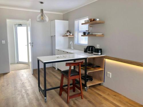 een keuken met een aanrecht en een tafel met een kruk bij BB BEACH BAY QUALITY APARTMENTs in Cape Town