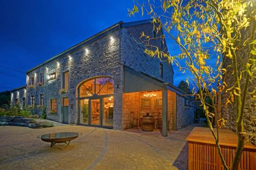 a stone building with a table in front of it at La Forge - Chambres d'hôtes en Ardenne in Wellin